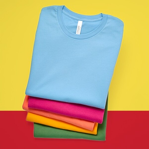 five t-shirts in different colors in folded stack on yellow and red background